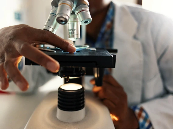 man places slide under microscope