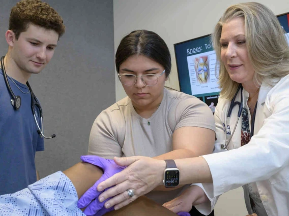Female medical instructure working with students and patient.