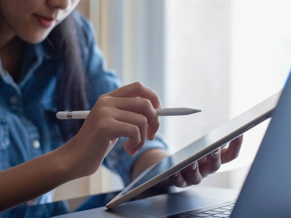 Woman pointing at a tablet with a digital pen.